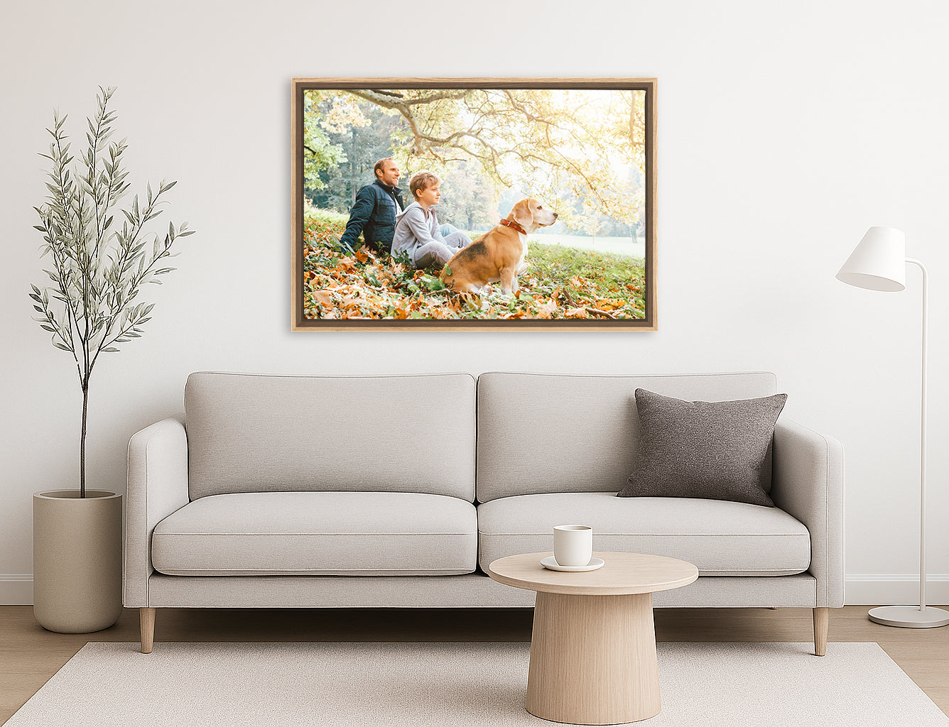Floating frame on canvas. Living room with a gray sofa, round coffee table, and a framed picture of a couple with a dog on the wall.