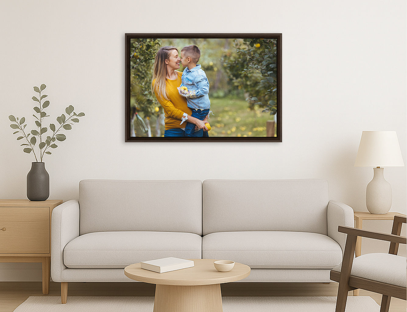 Framed photograph of a couple embracing on a wall above a sofa in a living room. A stylish Canvas floater picture frame.