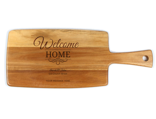 A wooden cheese board with 'Welcome Home' text engraved on it, with a handle on the side.