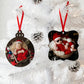 Two Metal Christmas tree ornaments personalised with photos of children in Santa hats on a white tree.