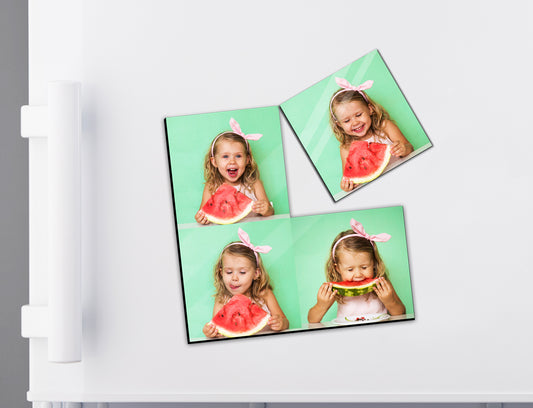 Four square magnet tiles with a child eating watermelon on a white surface